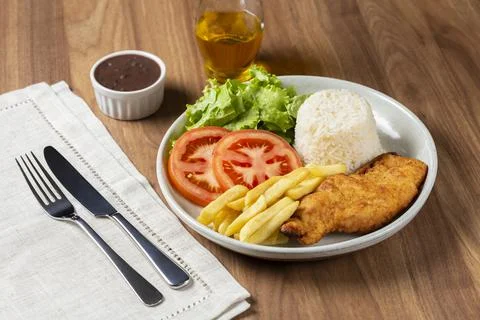 Executive dish with breaded fillet, rice, beans and salad. Stock Photos