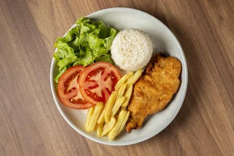 Executive dish with breaded fillet, rice, beans and salad. Stock Photos