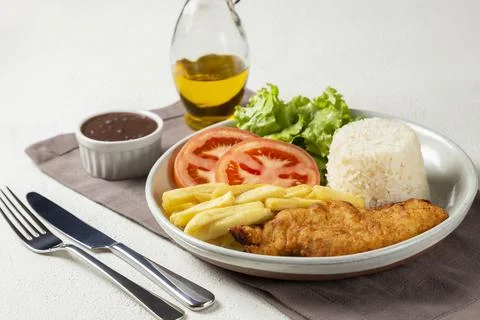 Executive dish with breaded fillet, rice, beans and salad. Stock Photos