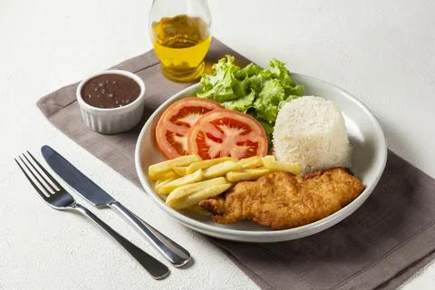 Executive dish with breaded fillet, rice, beans and salad. Stock Photos