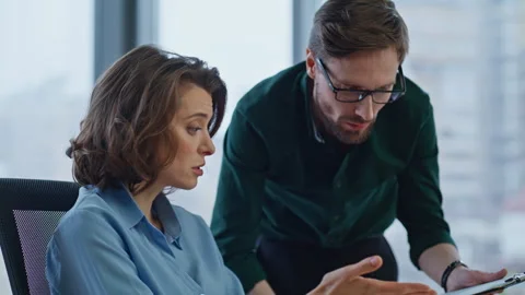 Executive explaining financial data in documents to woman manager at workplace. Stock Footage 340527736