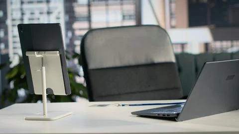 Executive office, empty, with laptop and stationery, natural light on furniture Stock Photos