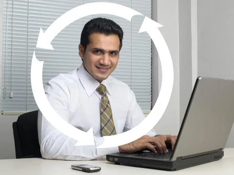 Executive operating laptop around with arrow sign MR 779K Copyright: xVire... Stock Photos