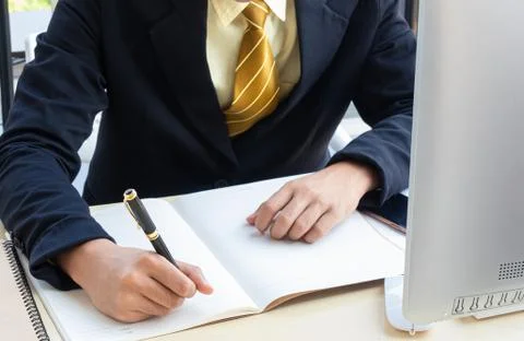 The executive is sitting on the desk, taking note of the creative ideas for t Foto stock