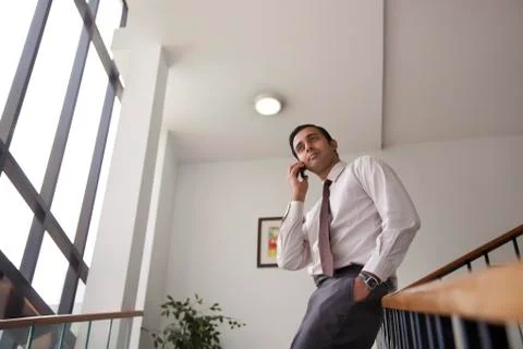 Executive on staircase talking on a mobile phone Stock Photos