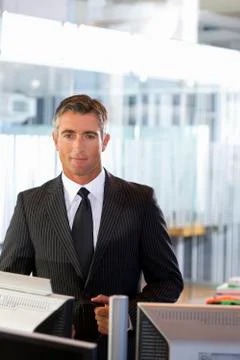 Executive standing in office Stock Photos