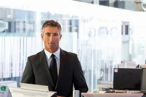 Executive standing in office Stock Photos