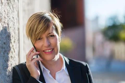 Executive talking on phone looking at camera on the street Stock Photos