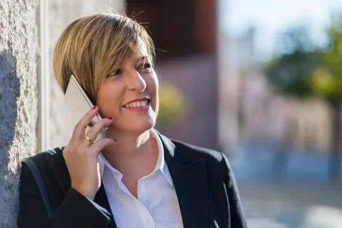 Executive talking on phone looking at camera on the street Stock Photos