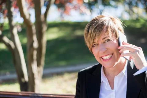 Executive talking on phone looking at camera on the street Stock Photos