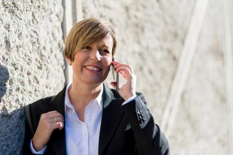 Executive talking on phone looking at camera on the street Stock Photos