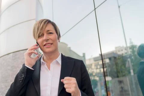 Executive talking on phone looking at camera on the street Stock Photos