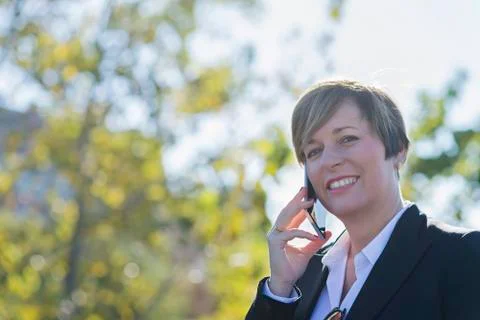 Executive talking on phone looking at camera on the street Stock Photos