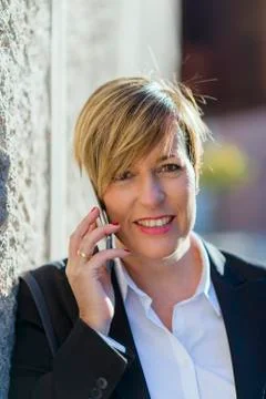 Executive talking on phone looking at camera on the street Stock Photos