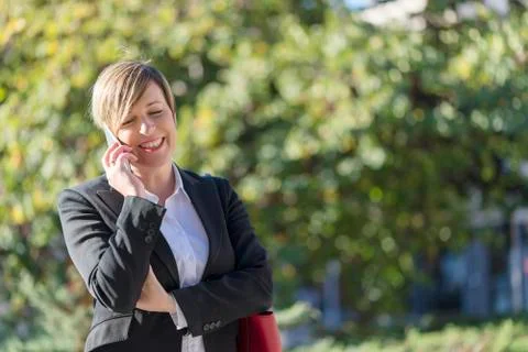 Executive talking on phone looking at camera on the street Stock Photos