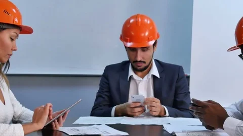 Executive team using smartphone and digital tablet sitting in office Vídeos de archivo 76112531