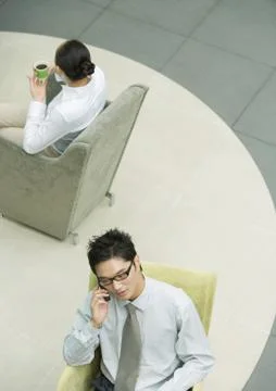 Executive using cell phone in lobby Stock Photos