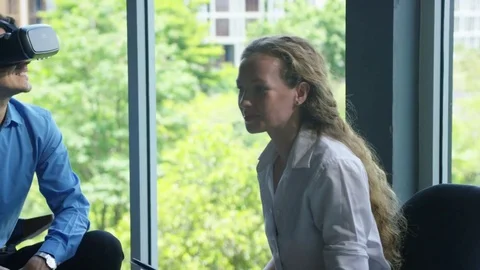 Executive using vr headset while having meeting with his colleagues in office Stock Footage 75451928