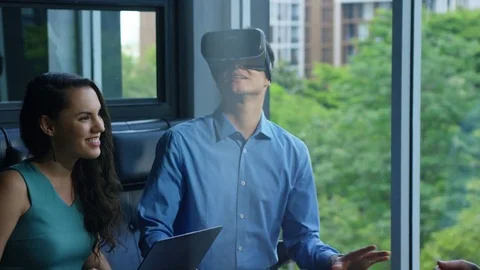 Executive using vr headset while having meeting with his colleagues in office Stock Footage 75451954