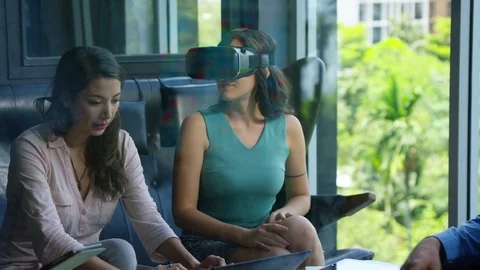 Executive using vr headset while colleagues discussing with each other in office Stock Footage 75452017