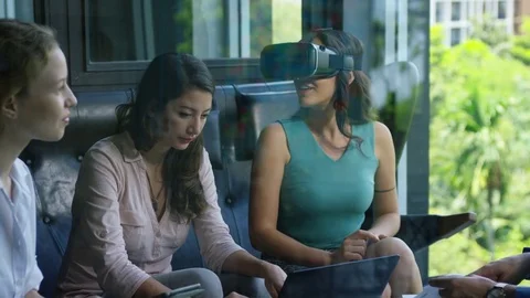 Executive using vr headset while having meeting with her colleagues in office Stock Footage 75452080