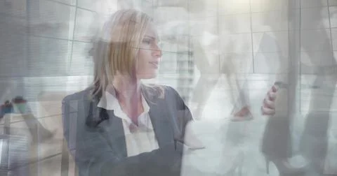 Executive wearing dark blazer and white top holding tablet, looking right by Stock Photos