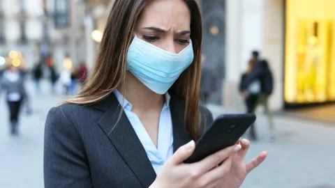 Executive wearing mask checking news on phone Stock Footage 126099470