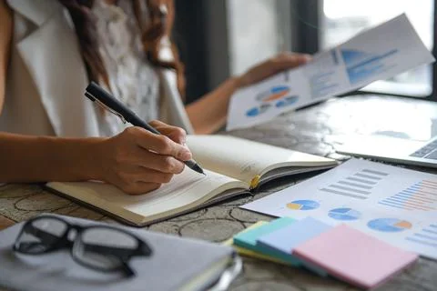Executive women are checking data from graphs and taking notes. Stock Photos
