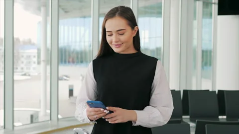 Executive working with a mobile phone in the office with airport terminal in the Video stock 89882282