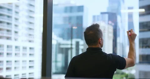 Executive writing ideas on a window in his office Stock Footage 112029119