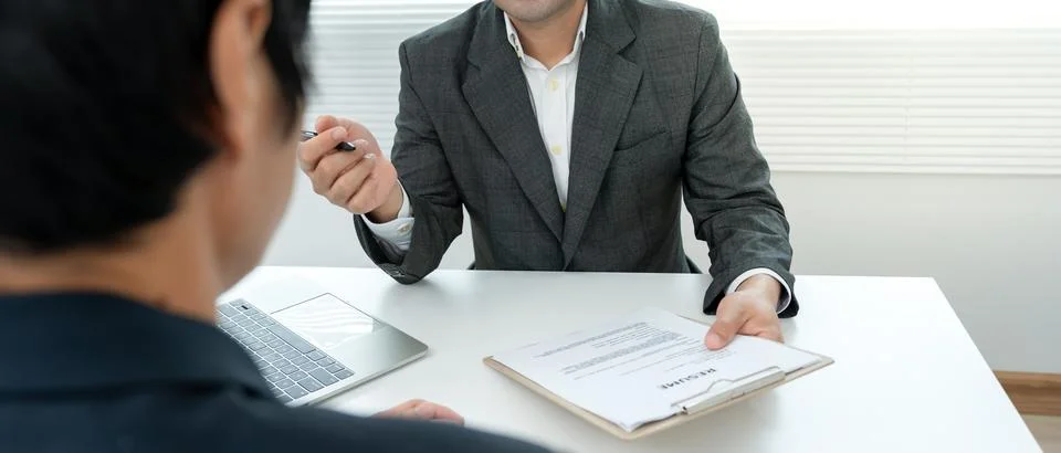 Executives accept job application documents and read job applicants resume .. Фото