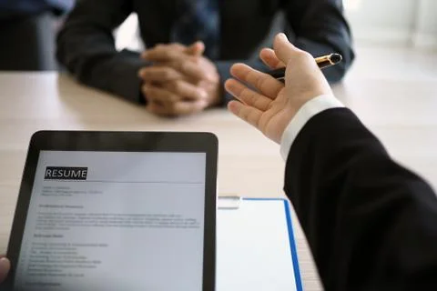 Executives are interviewing and watching the resume via tablet. Focus on resu Stock Photos