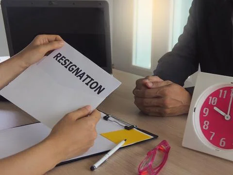 Executives are opening resignation envelopes of male employees sitting opposi Stock-Fotos