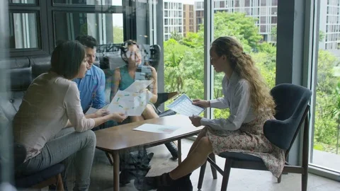 Executives discussing over document in office Stock Footage 75451552