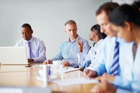 Executives in discussion before meeting. Executives in board room for meeting. Stock Photos