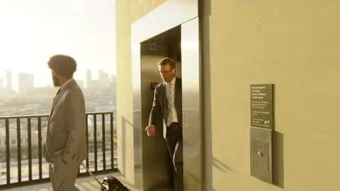 Executives Exiting Elevator onto Rooftop Parking Deck with City Skyline at Stock Footage 276195705