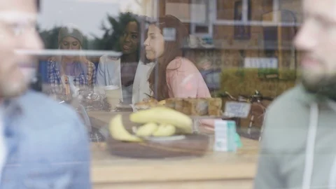 Executives having coffee and two women collecting take-away coffee from counter Stock Footage 108003900