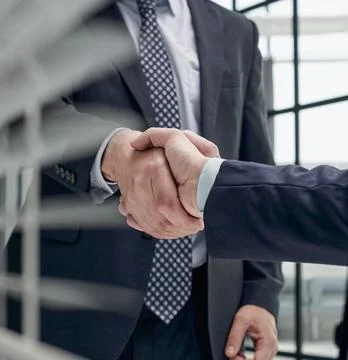 Executives shaking hands in front of their manager and a colleague 스톡 사진