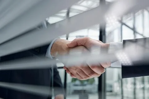 Executives shaking hands in front of their manager and a colleague Stock Photos