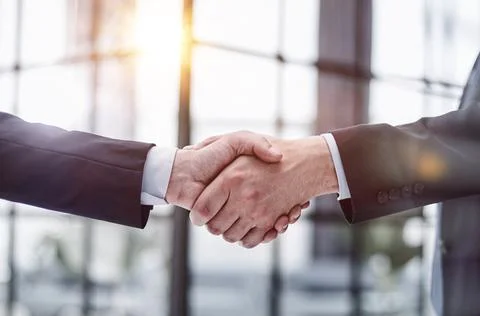 Executives shaking hands in front of their manager and a colleague Photos
