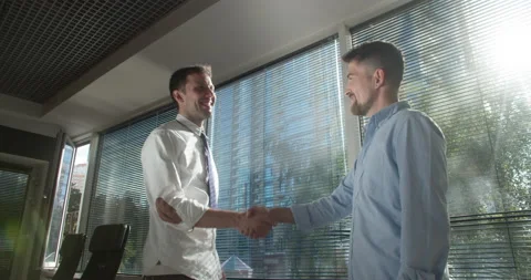 Executives shaking hands while interacting in office premises Stock Footage 157734512