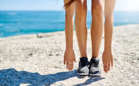 Exercise allows me to push my body to the limit. a young woman stretching down Stock Photos