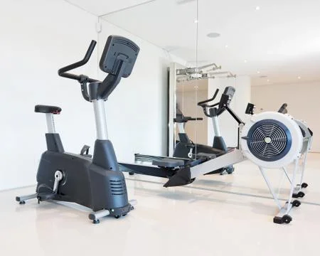 Exercise bike and rowing simulator in the luxury gym close-up. Stock Photos