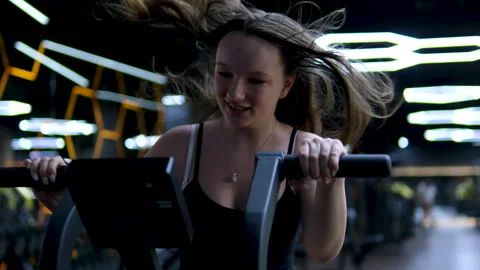Exercise bike Close-up, spinning wheel. The girl's legs pedal on the exercise Stock Footage 307486345