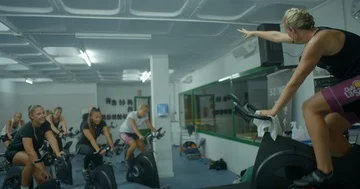 An Exercise Bike instructor teaching her class ups the pace. Video stock 85536563