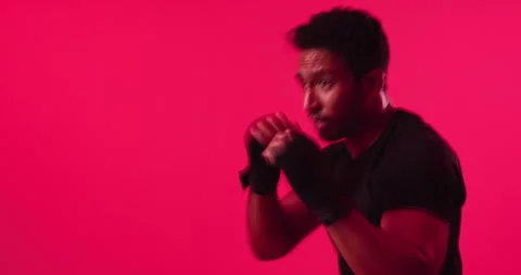 Exercise, boxing and man in studio for training, self defense or workout on red Stock Footage 330989917