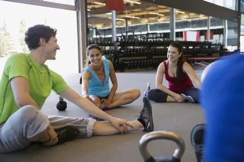 Exercise class stretching hamstrings in gym Stock Photos