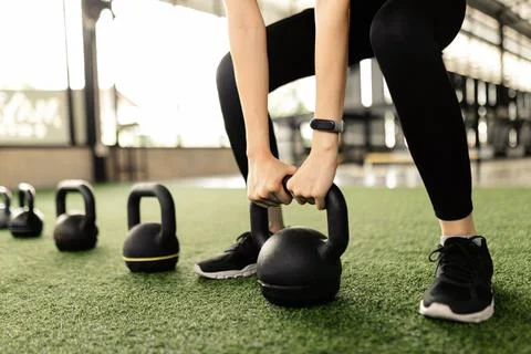 Exercise concept The black kettlebells being lined on the green carpet for be Stock Photos