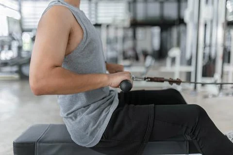 Exercise concept The brawny guy in the exercise club paying his attention on Stock Photos