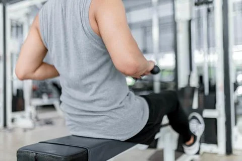 Exercise concept The brawny guy in the exercise club paying his attention on Stock Photos